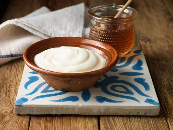 Greek yogurt and honey on tile — Stock Photo, Image