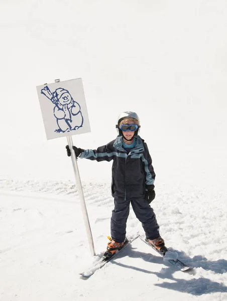 雪だるまの記号を保持している少年スキーヤー — ストック写真