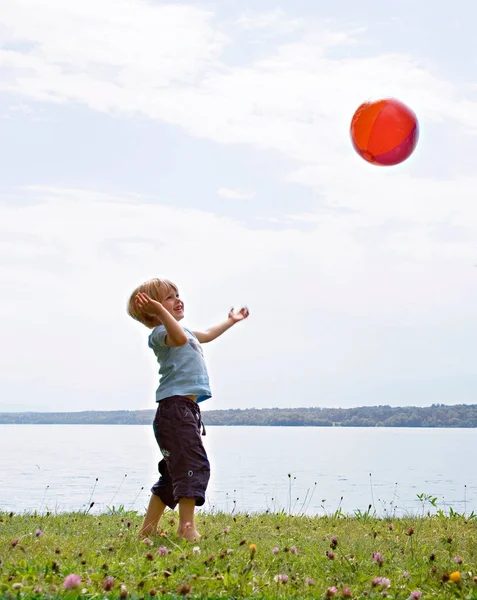 Chłopiec Gra Piłką Nad Jeziorem — Zdjęcie stockowe