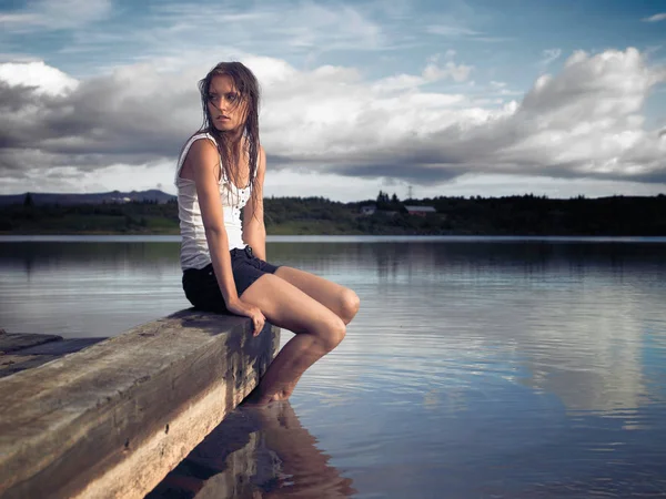 Nainen Istuu Järven Rannalla — kuvapankkivalokuva