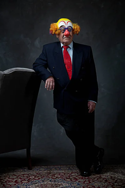 Portrait of a senior businessman in a clown mask