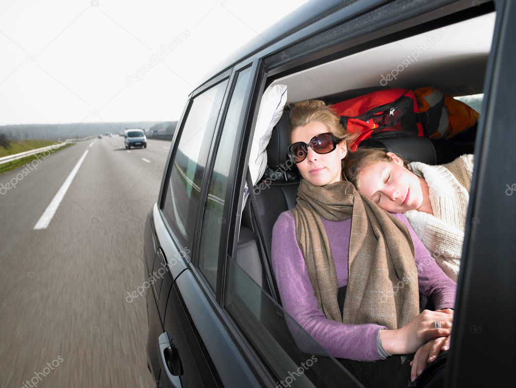 Young women sleeping in car