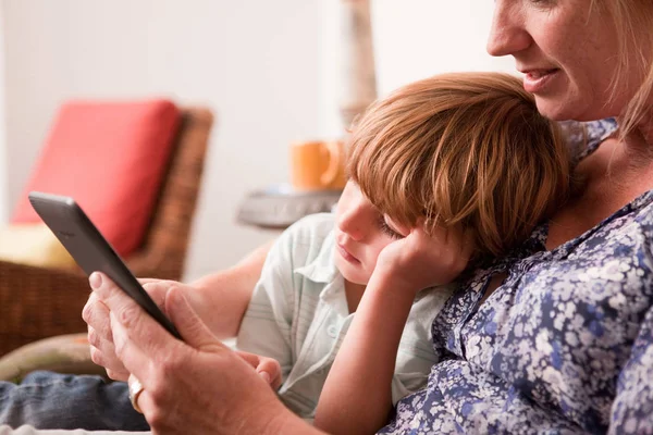 Hijo Sentado Lado Madre Mientras Ella Usa Una Tableta Digital — Foto de Stock