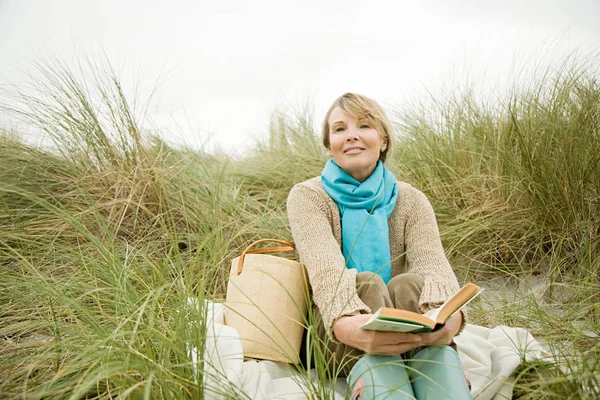 Woman with a book on a dune