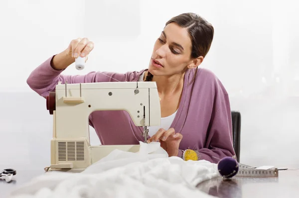 Una dama ajustando su máquina de coser — Foto de Stock