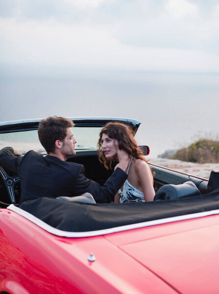 couple sitting in open-topped car