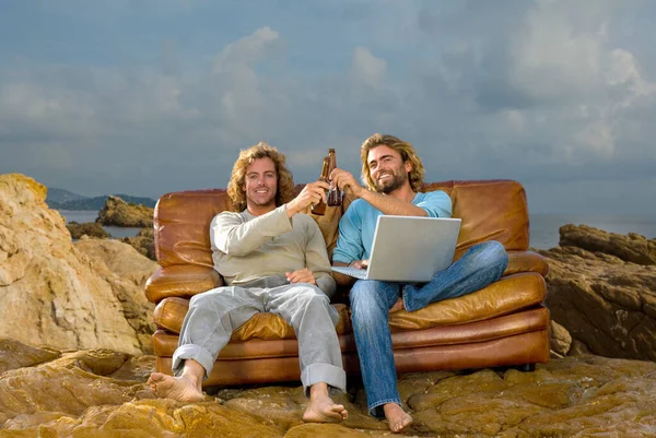 Young men with laptop and beer, couch at — Stock Photo, Image