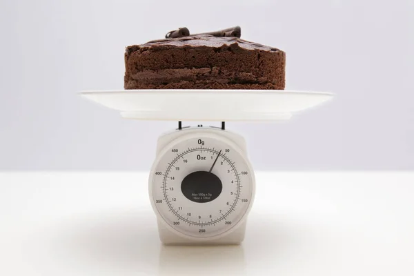 スケール上のチョコレートケーキ — ストック写真