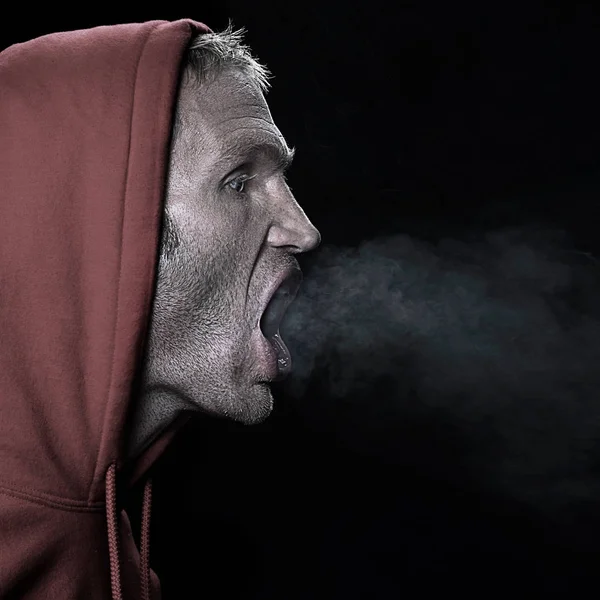 Man Breathing Out Hood – stockfoto