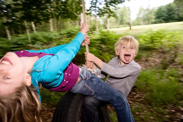 男孩和女孩在轮胎秋千上 — 图库照片