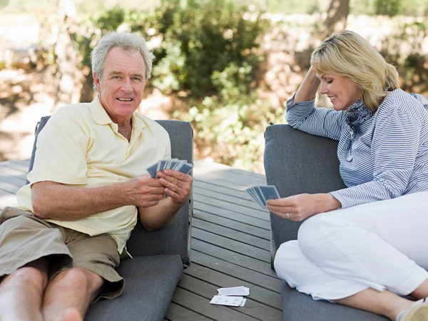 Mature couple playing cards outdoors