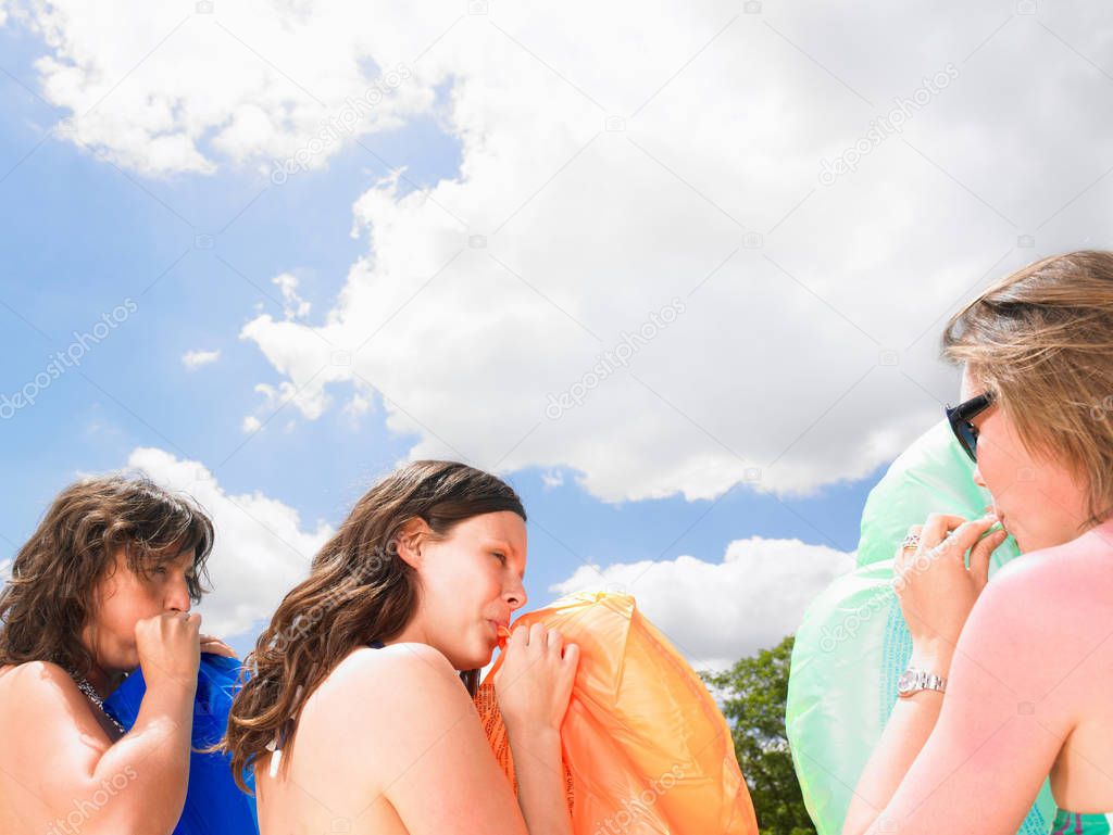 young women with pool mattresses