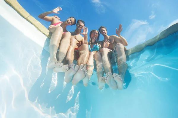 Amigos saludando desde el borde de la piscina — Foto de Stock