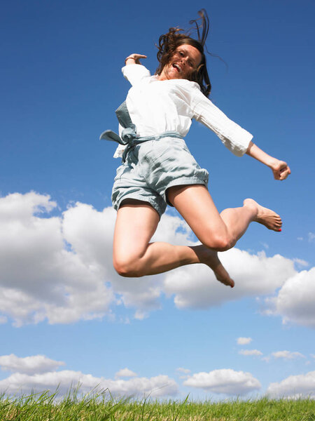 young woman jumping over sky 