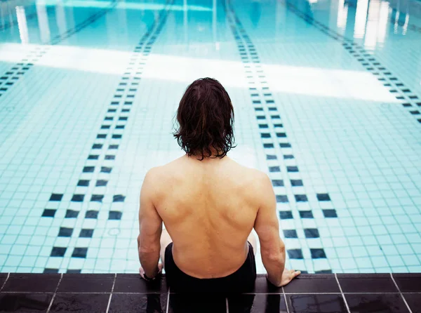 坐在室内游泳池边的成熟男人 — 图库照片