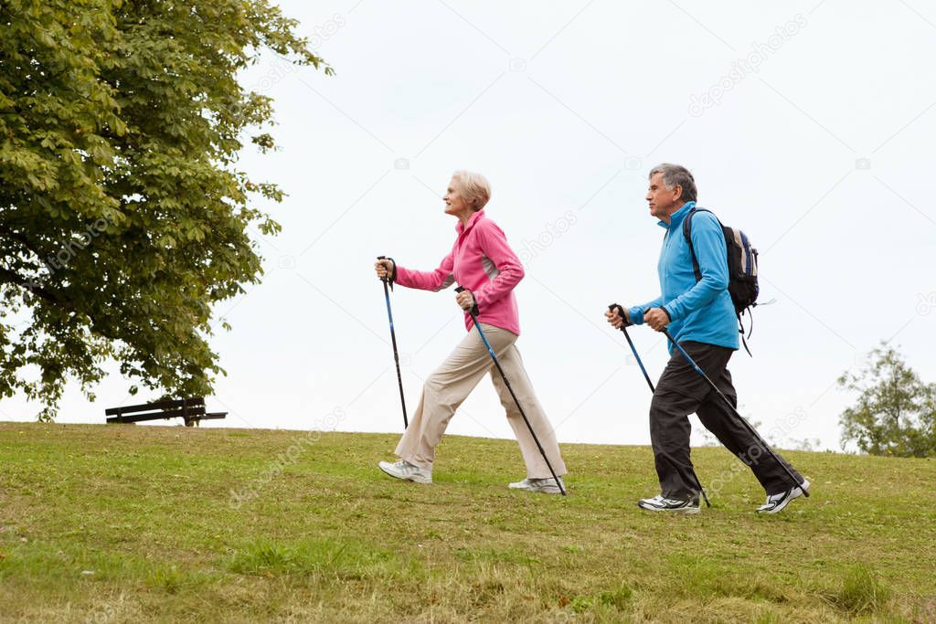 Mature couple nordic walking in park