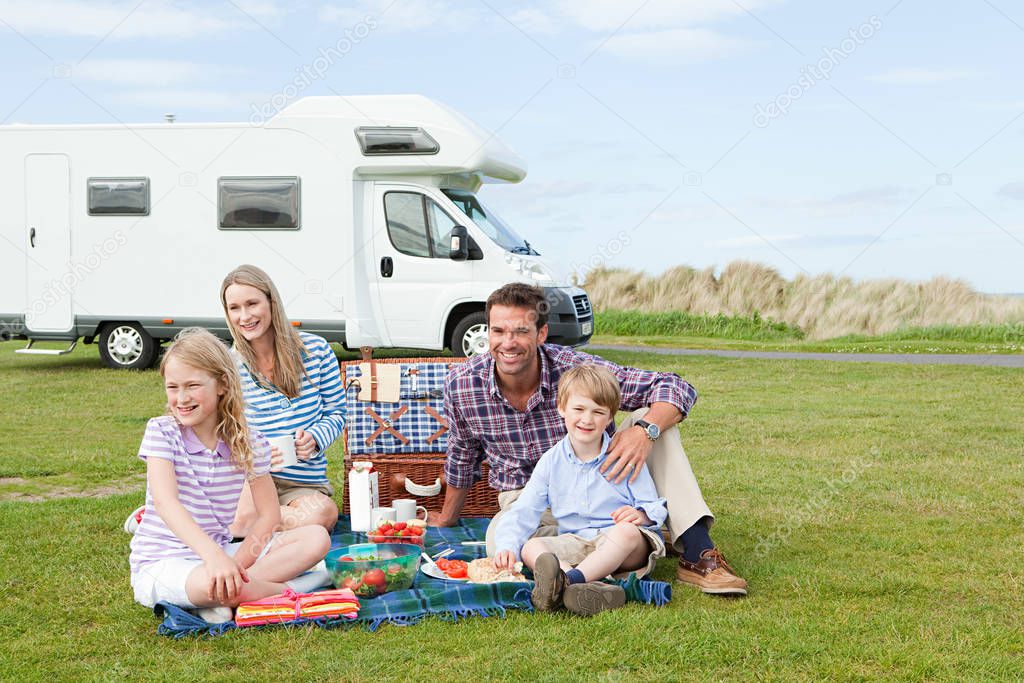 Family having picnic by caravan