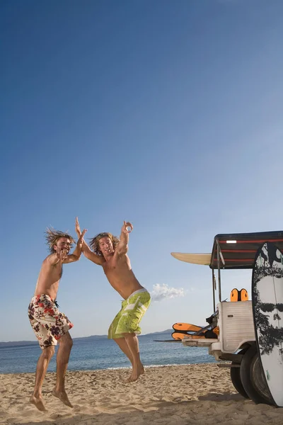 Jovens saltam na praia de jipe — Fotografia de Stock