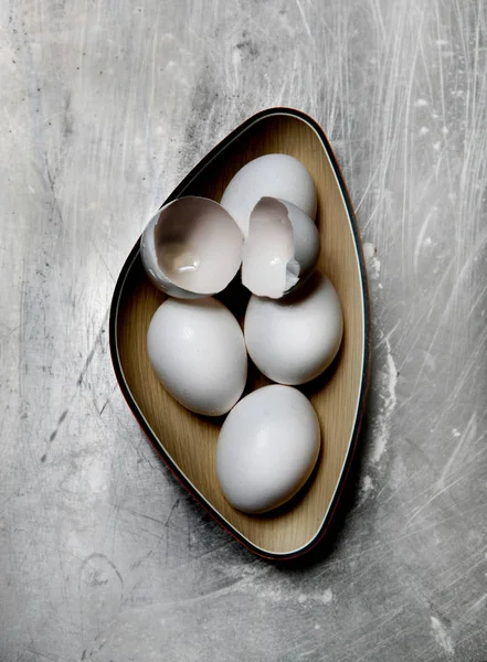 Huevos y cáscaras de huevo en tazón — Foto de Stock