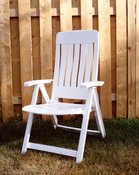 Garden chair by fence — Stock Photo, Image