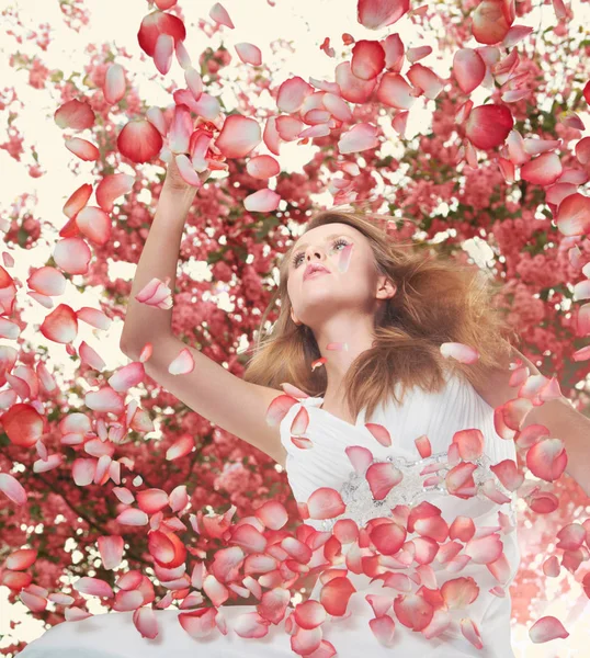 Mulher cercada por pétalas de flores — Fotografia de Stock