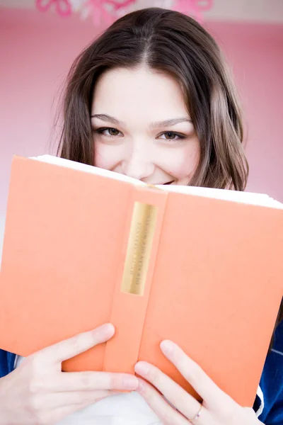 Mädchen Schaut Betrachter Mit Buch — Stockfoto