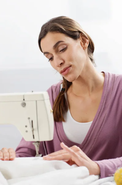Una señora que trabaja en una máquina de coser — Foto de Stock
