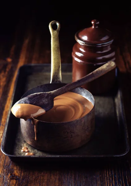 Saucepan of chocolate sauce on tray — ストック写真