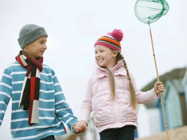 Ragazzo e ragazza passeggiando lungo la spiaggia — Foto Stock