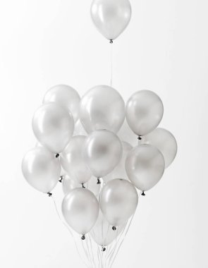 Beyaz arkaplanda yüzen gümüş balonlar