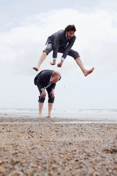 Empresários brincando na praia — Fotografia de Stock