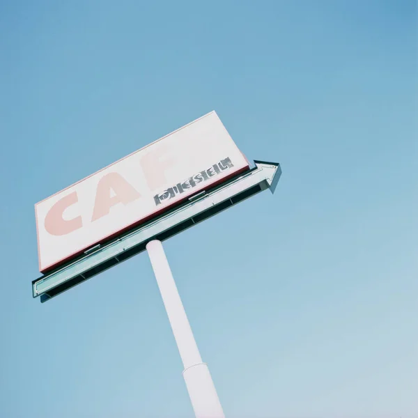 Cafe sign against blue sky
