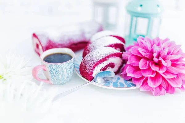 Un rollo de torta de terciopelo rojo rebanado con taza de café o té y flores . — Foto de Stock