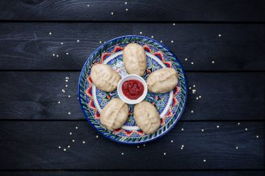 Geleneksel köfte mantı plaka ile şark süsleme domates soslu buğulama. Üstten Görünüm. Koyu ahşap arka plan