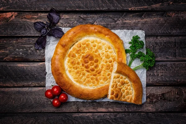 Traditionelles Tandyr-Brot aus Zentralasien mit Gemüse auf einem hölzernen Hintergrund. Ansicht von oben — Stockfoto
