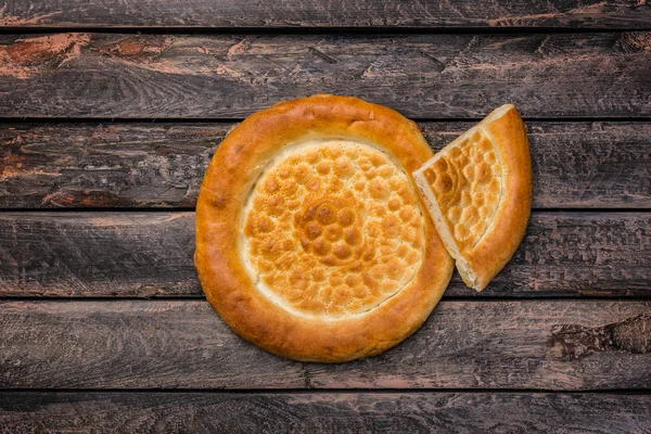 Orta Asya 'nın geleneksel tandyr ekmeği ahşap bir arka planda. Üst görünüm