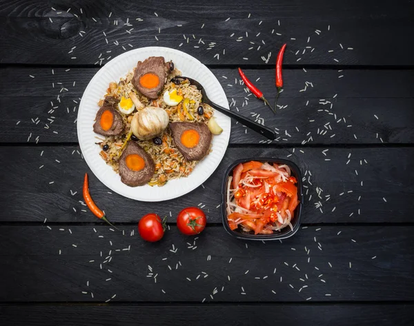 Pilaf a achichuk na bílé desce. Dřevěné tmavé pozadí. Střední-asijské kuchyně - Plov. Pohled shora — Stock fotografie