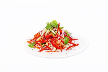 Kırmızı biber ve sebze ve susam Pan-Asya baharatlı salatası. Beyaz bir arka plan üzerinde beyaz bir plaka üzerinde