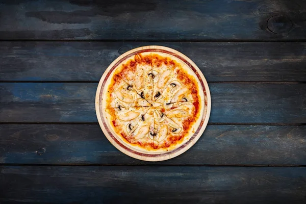 Вкусная пицца с грибами и курицей на деревянном подставке на темном деревянном фоне. Ориентация центра обзора — стоковое фото