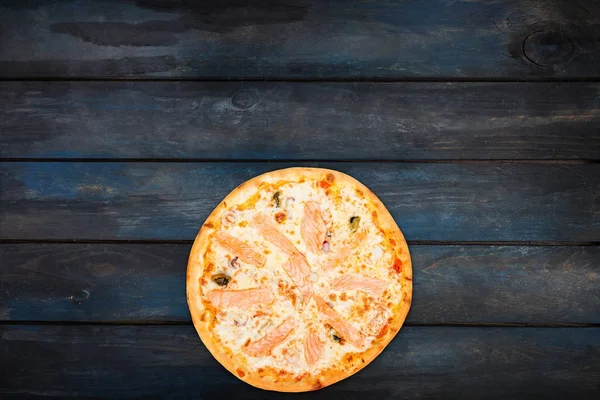 Frische klassische Pizzai mit Meeresfrüchten auf dunklem Holzgrund. von oben Ansicht von unten Orientierung — Stockfoto