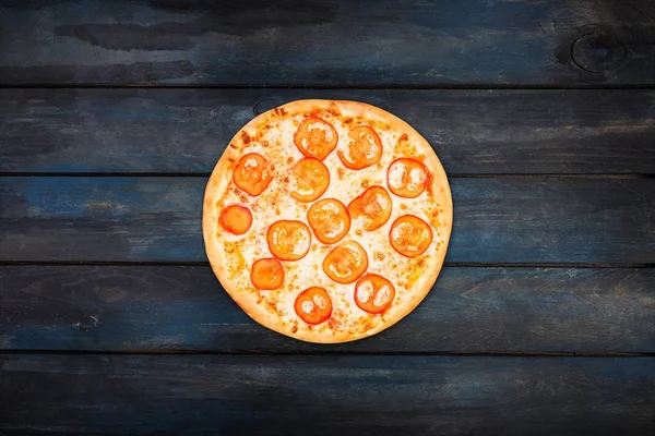 Perfekte Pizza Margarita mit Tomatenscheiben auf dunklem Holzgrund. Orientierung im Zentrum von oben — Stockfoto