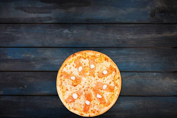 Leckere Pizza mit Lachs und Philadelphia-Käse auf dunklem Holzgrund. von oben Ansicht von unten Orientierung — Stockfoto