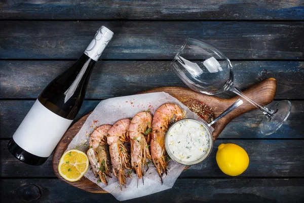 Büyük karides veya bilinenlerin beyaz sos, şarap, şarap için cam ve ahşap bir gemide bir limon yarısı. Üstten Görünüm