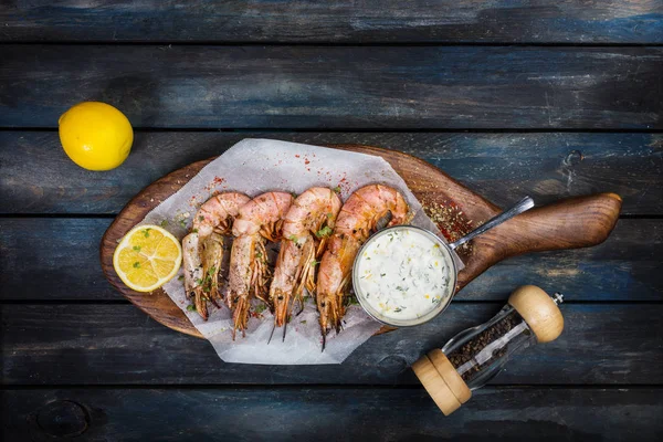 Lezzetli Arjantinli karides veya bilinenlerin beyaz sos biber-pot ve ahşap bir tahtada yarım limon ile. Üstten Görünüm