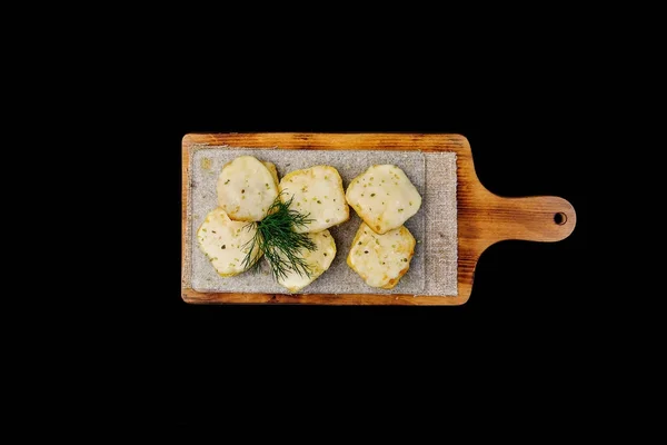Roti dengan keju. Bawang putih goreng croutons dengan dill. Di papan kayu. Pemandangan bagus. Terisolasi pada latar belakang hitam — Stok Foto