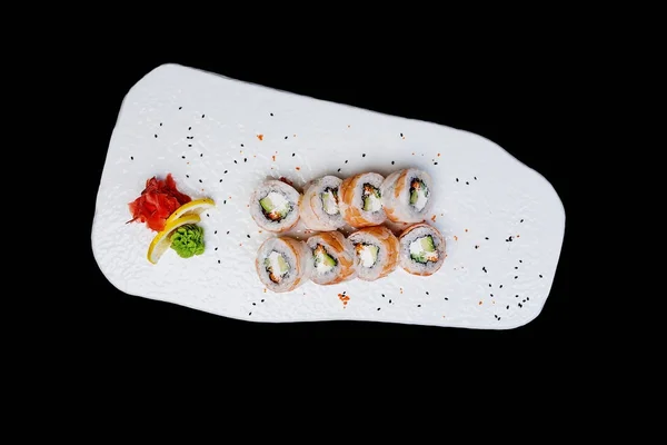 Philadelphia roll with a cucumber, avocado, some cream cheese, tobiko caviar and shrimp. Top view. Isolated on a black background — Stock Photo, Image