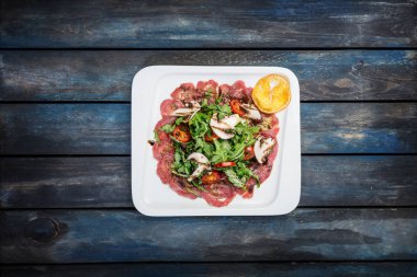 Ahşap zemin üzerine mantarlı Dana carpaccio çatal ile görev yaptı.