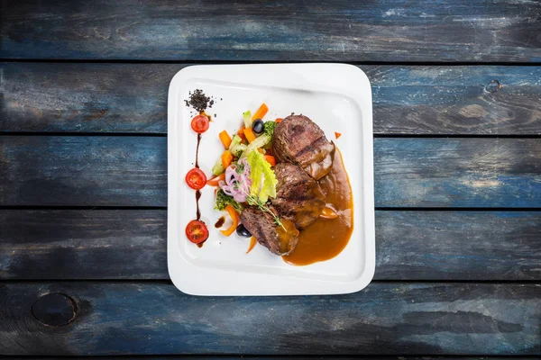 Bife de pimenta com legumes no prato branco — Fotografia de Stock