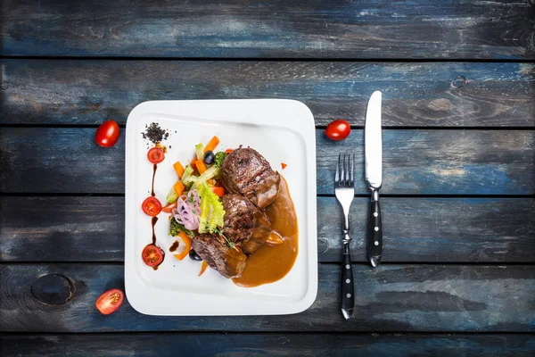 Pepper steak with vegetables on the white plate