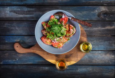 Salata domates soğan maydanoz ve rustik bir tahta üzerinde susam yağıyla iki tür. Üstten Görünüm